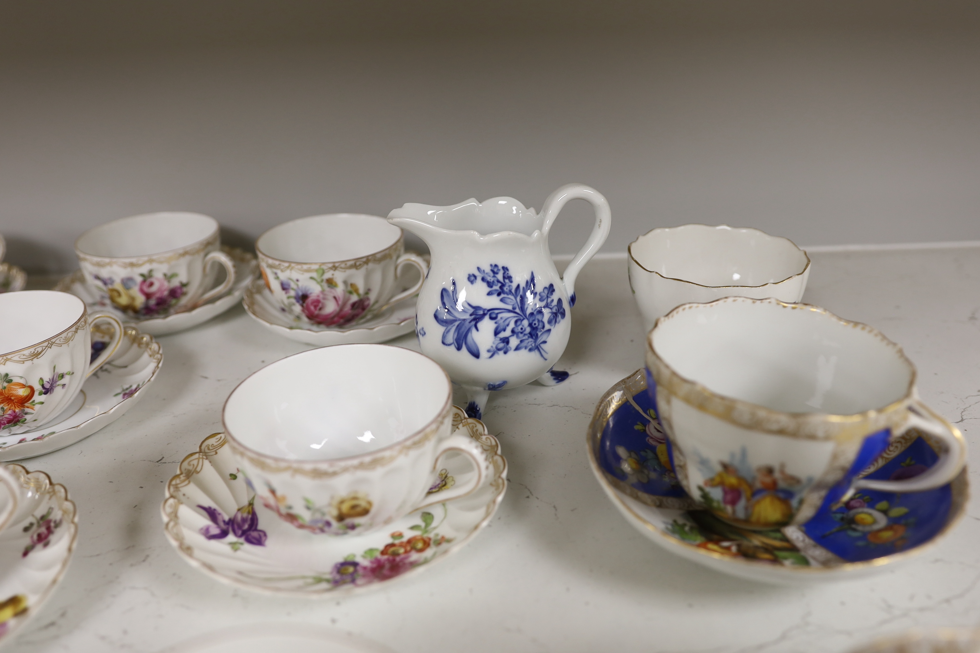 A group of porcelain Dresden tableware including cups and saucers and a blue and white jug